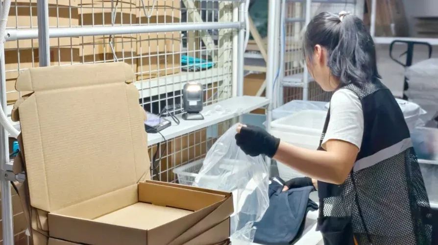 Warehouse worker preparing protective packaging in a carton